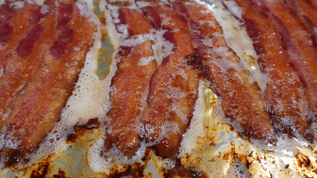 Perfectly cooked bacon sitting in grease